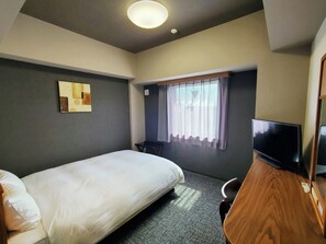A hotel room with a single bed, a television, a desk, and a window with curtains. - Hotel Route-Inn Kameyama Inter (Kameyama)