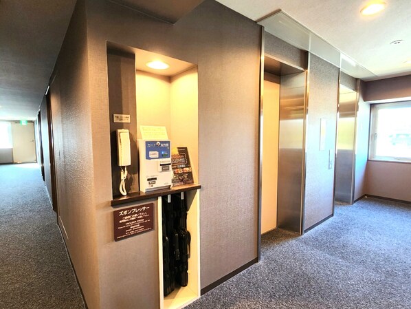 A hotel room with a minibar, a telephone, a card reader, and a coat rack. - Hotel Route-Inn Kameyama Inter (Kameyama)