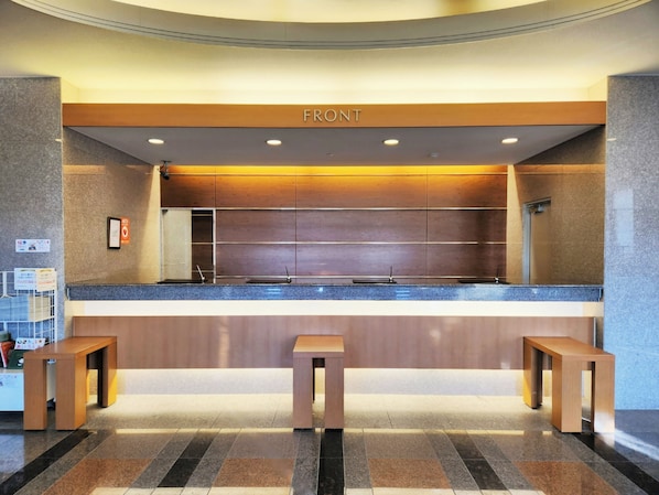 A reception area with a counter, two wooden benches, and a sign labeled 'FRONT'. - Hotel Route-Inn Kameyama Inter (Kameyama)