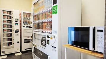 A vending machine with various beverages, a microwave, and a refrigerator.