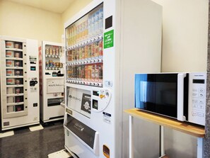 A vending machine with various beverages, a microwave, and a refrigerator. - Hotel Route-Inn Kameyama Inter (Kameyama)