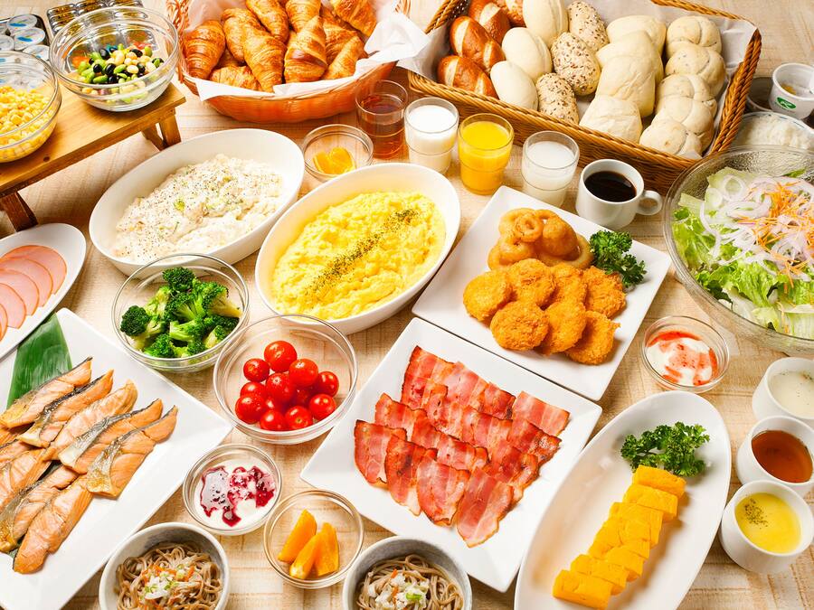 A variety of breakfast foods including eggs, bacon, salmon, and pastries.