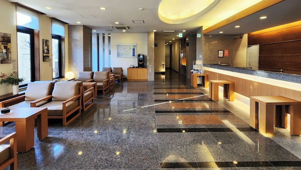 A hotel lobby with seating, a reception desk, and a large illuminated ceiling feature. - Hotel Route-Inn Kameyama Inter (Kameyama)