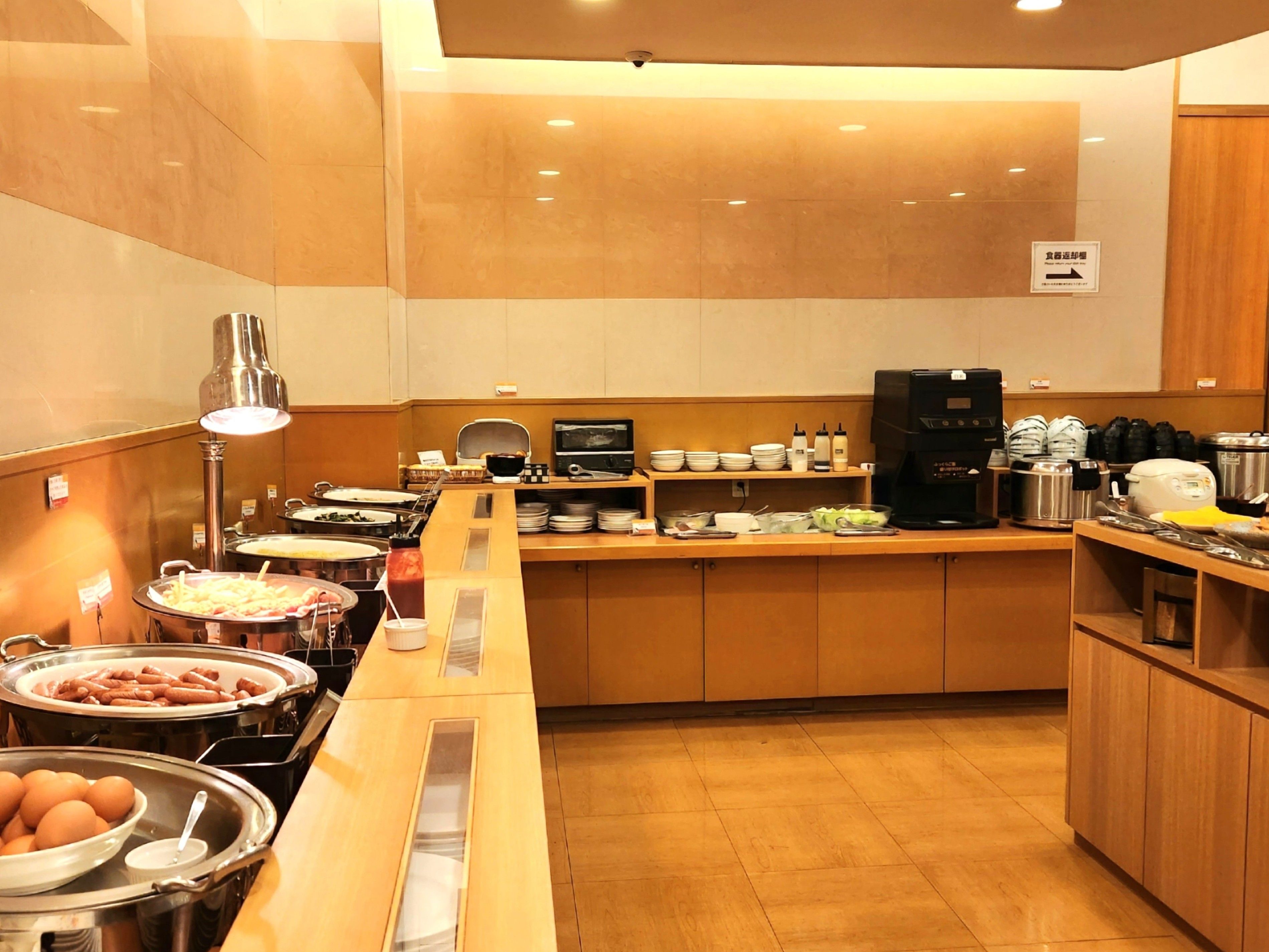 A buffet setup with various food items and a coffee machine.
