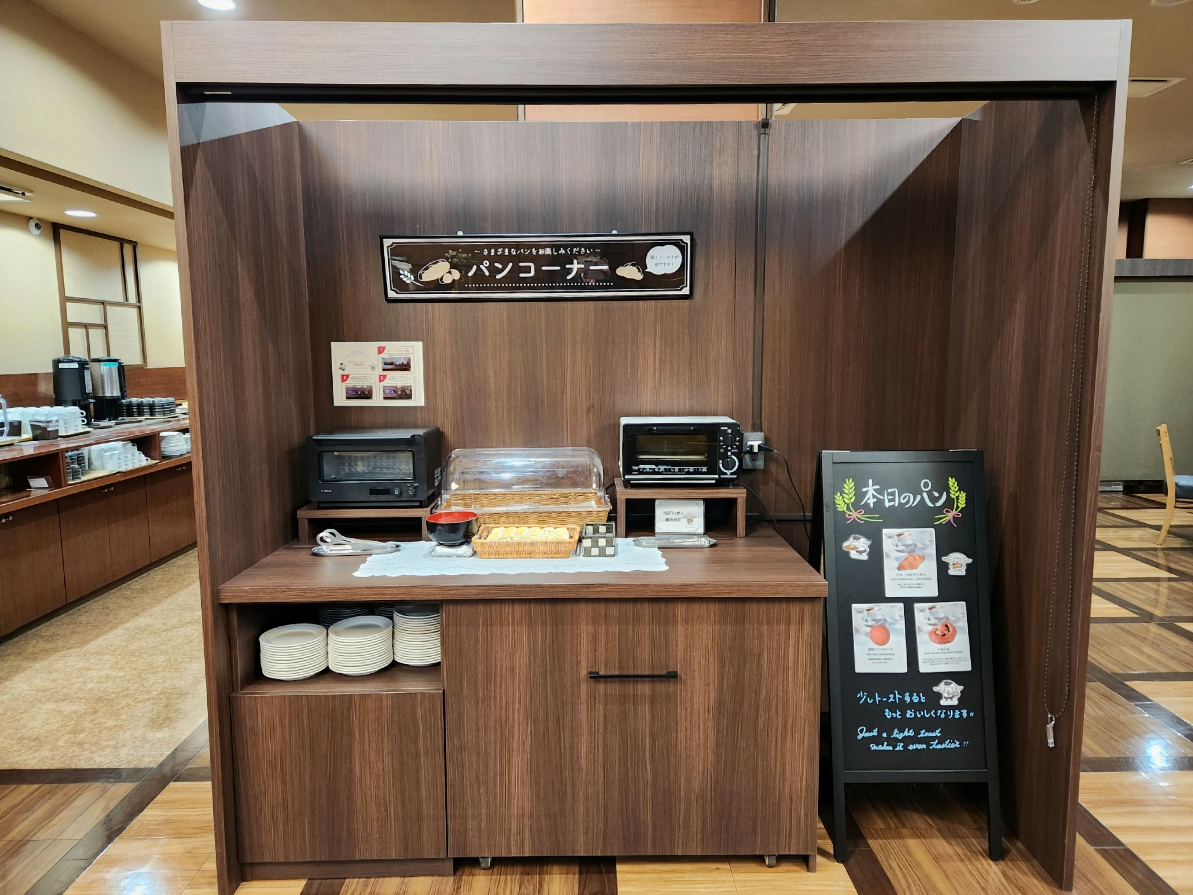 A self-service coffee station with a sign, a toaster, a microwave, and a menu board.