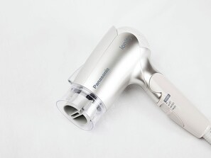 Un sèche-cheveux Panasonic doté d’un embout transparent et d’un manche blanc.