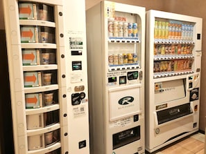 Des distributeurs automatiques de boissons et de collations, un code QR et un logo pour la chaîne d’hôtels Route Inn.