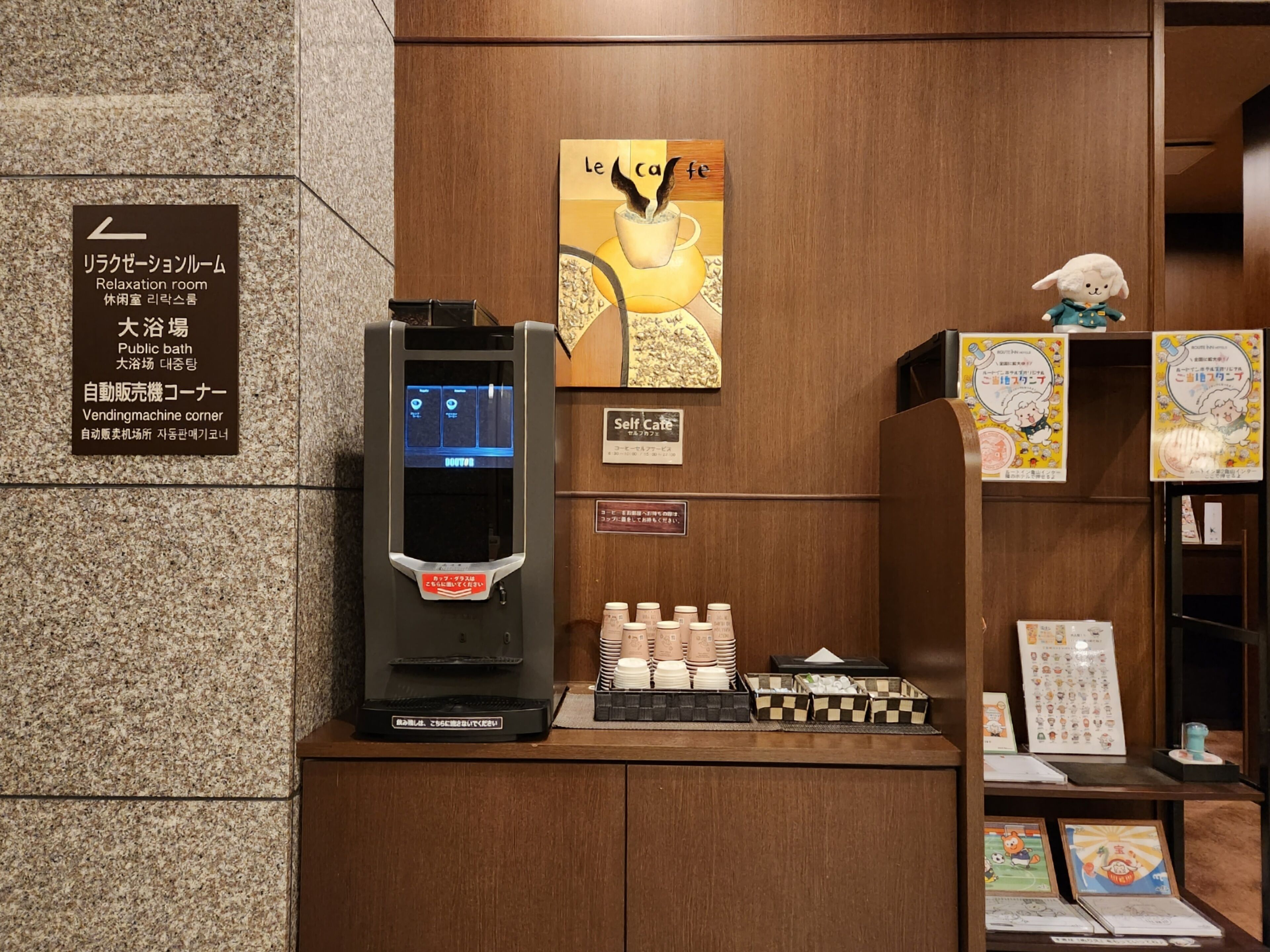 Un distributeur automatique, une affiche d’un café et un panneau indiquant l’emplacement d’une salle de détente.