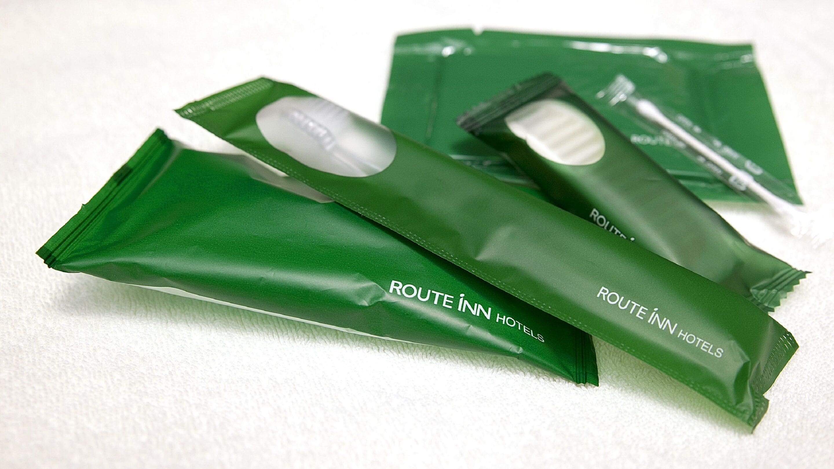 Three green packages labeled "ROUTE INN HOTEL" on a white surface.