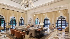A spacious living room with a large sofa, armchairs, a coffee table, and a chandelier. - Sawai Man Mahal, Jaipur (Jaipur)