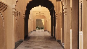 A corridor with arches and columns, leading to a garden area. - Sawai Man Mahal, Jaipur (Jaipur)
