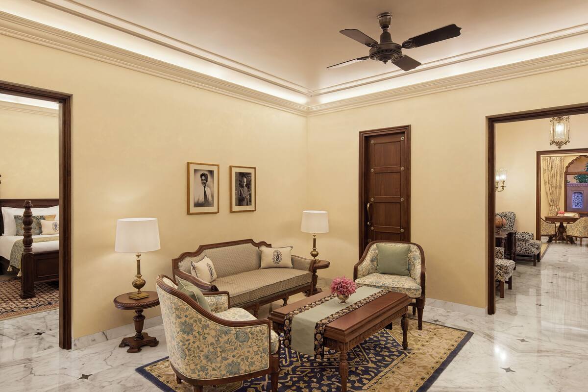 A well-appointed living room with a sofa, armchairs, a coffee table, and a ceiling fan.