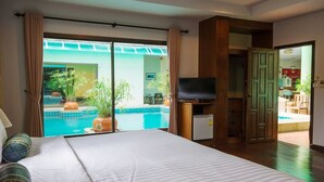 Een hotelkamer met een groot bed, een televisie en uitzicht op een zwembad.