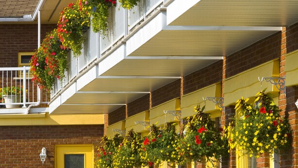 Un edificio de varios pisos con balcones decorados con jardineras.