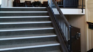 Una escalera con barandales de metal que sube a un segundo piso.
