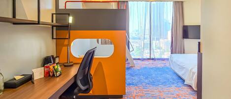 A hotel room with a bunk bed, desk, chair, and a large window with a city view.