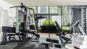 A gym with various exercise equipment, including a bench, weight machines, and a treadmill. - Holiday Inn Express Bangkok Siam by IHG (Bangkok)