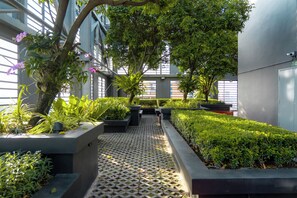 An indoor garden with a variety of plants and a patterned walkway. - Holiday Inn Express Bangkok Siam by IHG (Bangkok)