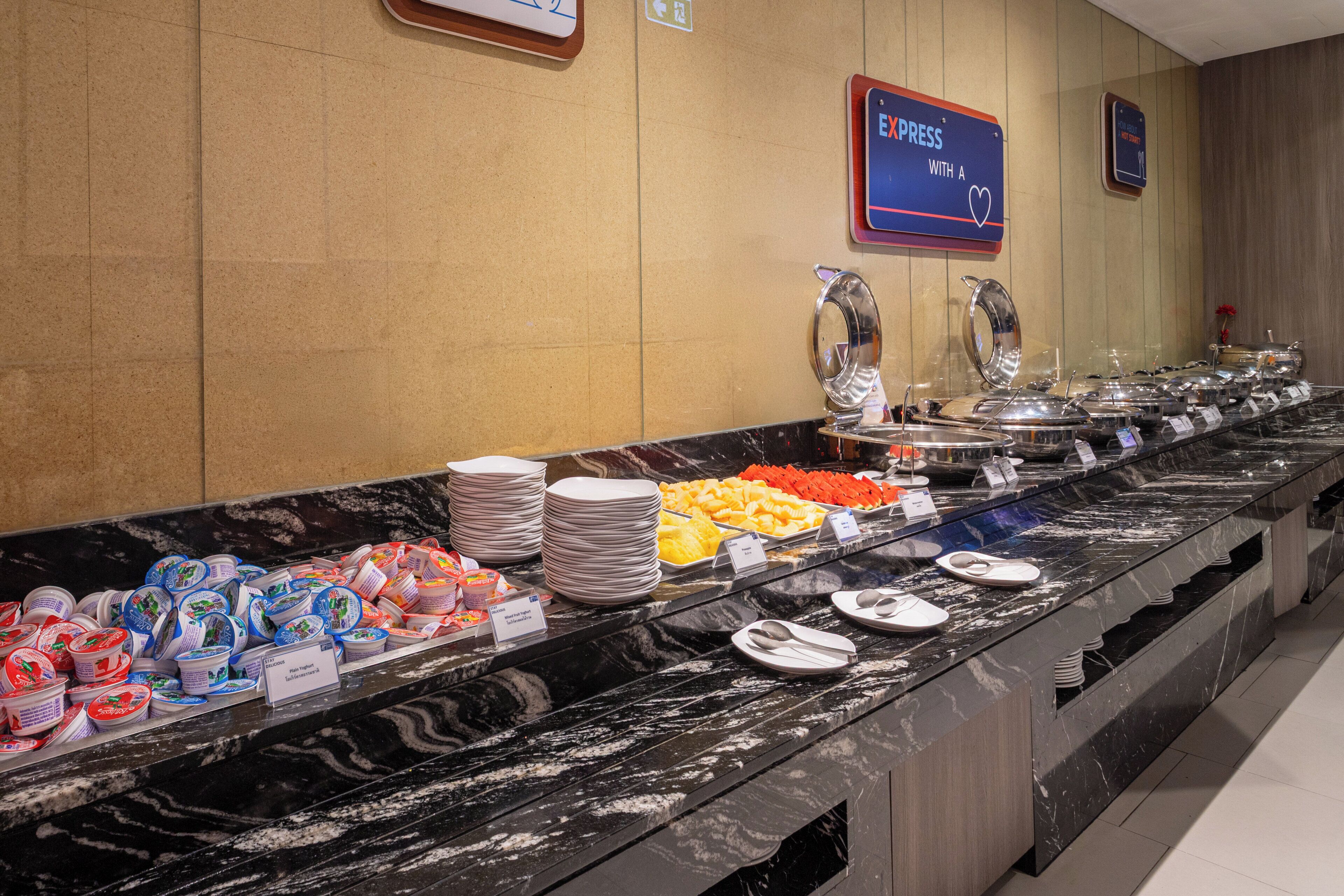 Um buffet com diversos alimentos e utensílios de servir.