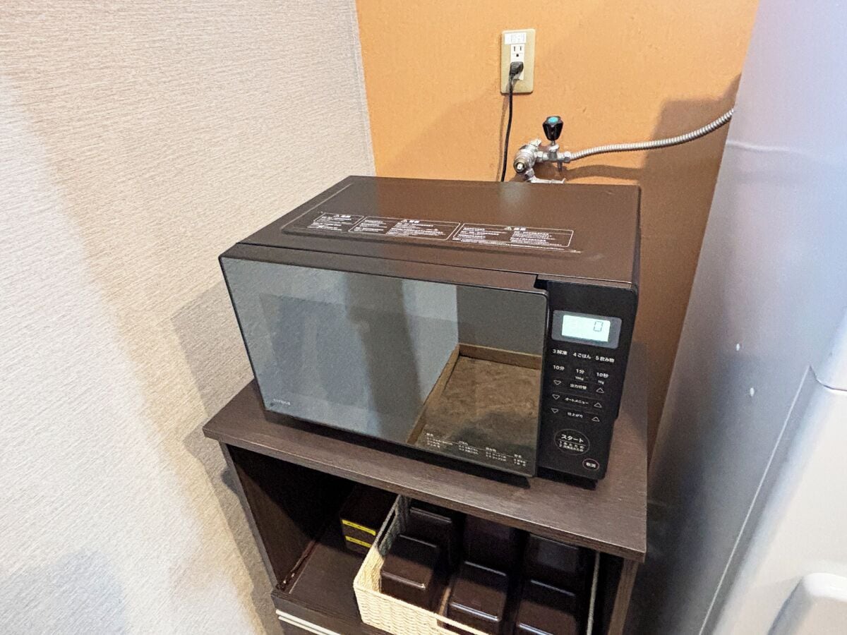 Un horno microondas sobre una encimera de madera con un panel de control.