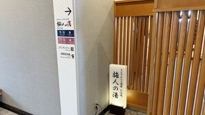 Un espace de bains publics avec des panneaux indiquant des zones séparées pour les hommes et les femmes.