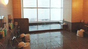 Een moderne badkamer met een groot raam, een badkuip en meerdere douchekoppen.