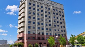 Un edificio de hotel de varios pisos con fachada plana, numerosas ventanas y un letrero que indica que es un hotel.