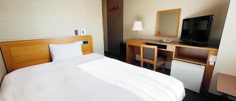 Quarto de hotel com uma cama grande, uma escrivaninha com televisão e um pequeno frigorífico.