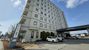 Un hôtel à plusieurs étages avec un parking situé à l’avant.