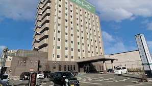 Un hotel de varios pisos con un letrero verde en la parte superior.