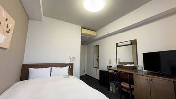 A hotel room with a bed, a desk, a television, and a mirror.