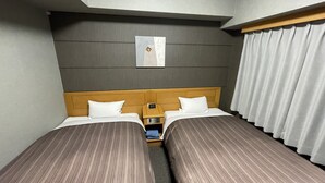 A hotel room with two beds, a nightstand, a wall-mounted clock, and a window with curtains. - Hotel Route-Inn Yukuhashi (Yukuhashi)