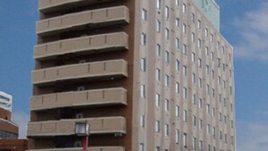A multi-story hotel with a prominent green and white logo on the top. - Hotel Route-Inn Isahaya Inter (Isahaya)
