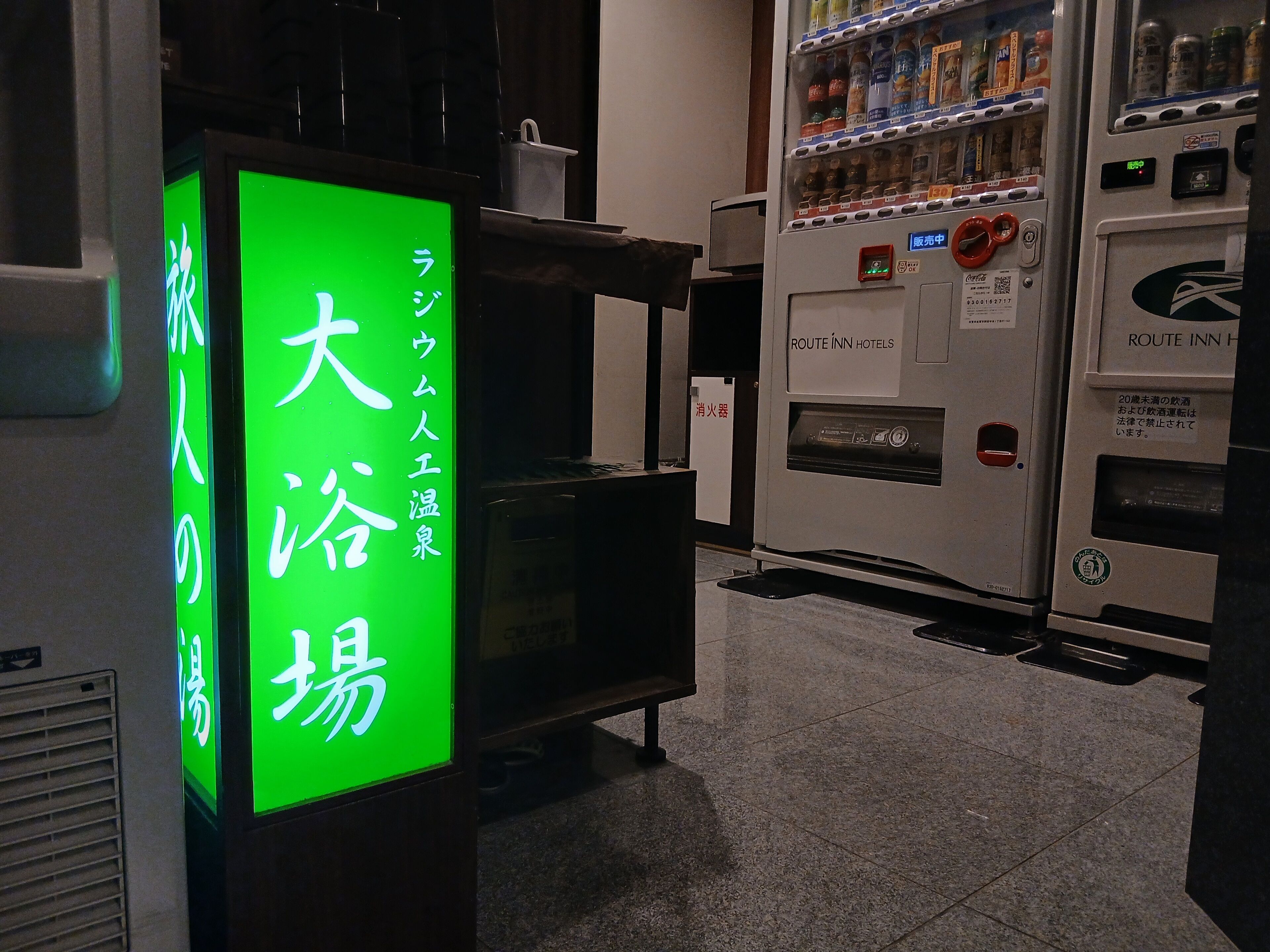 Máquina expendedora con pantalla digital y un rótulo con caracteres japoneses.