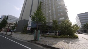 A multi-story hotel with a modern design, featuring a prominent vertical structure and a flat roof. - Hotel Route - Inn Saga Ekimae (Saga)