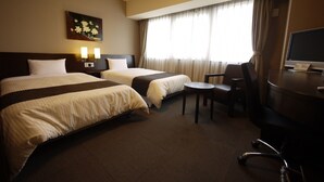 A hotel room with two beds, a desk with a computer, a chair, and a small table. - Hotel Route - Inn Saga Ekimae (Saga)