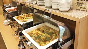 A buffet setup with various dishes, including a soup and fried items, and a sign with Japanese text. - Hotel Route Inn Tosu Ekimae (Tosu)