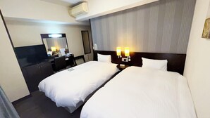 A hotel room with two beds, a desk, a chair, a TV, and a mirror. - Hotel Route Inn Tosu Ekimae (Tosu)