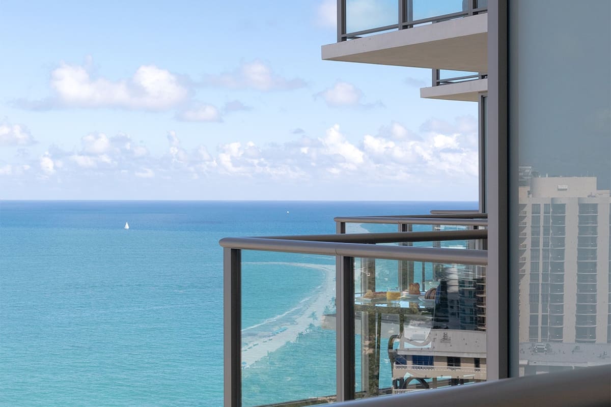 Un edificio alto con varios balcones que dan a una playa y al océano.