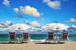 On the beach, white sand, beach cabanas, sun loungers