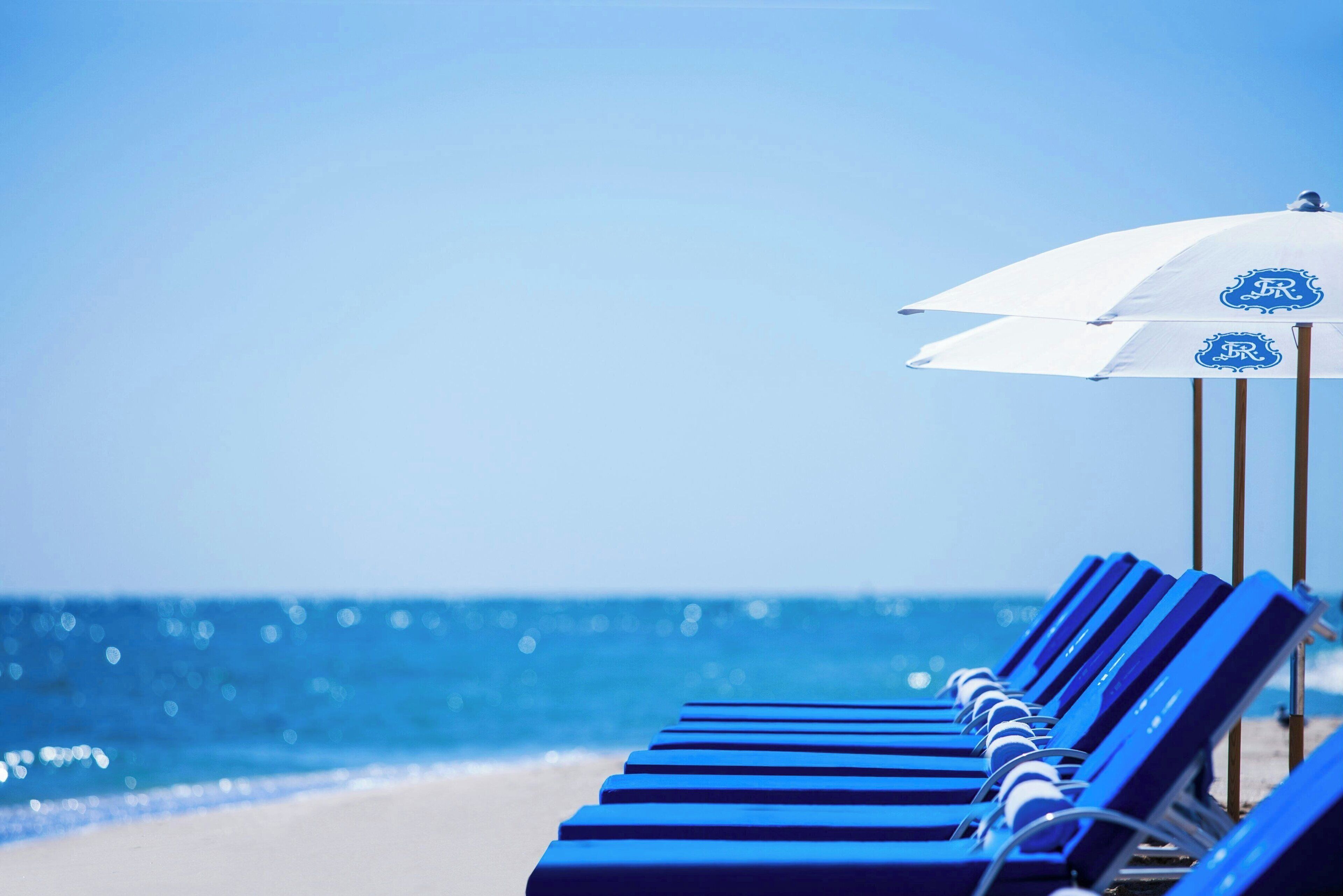 on the beach, white sand, beach cabanas, sun-loungers