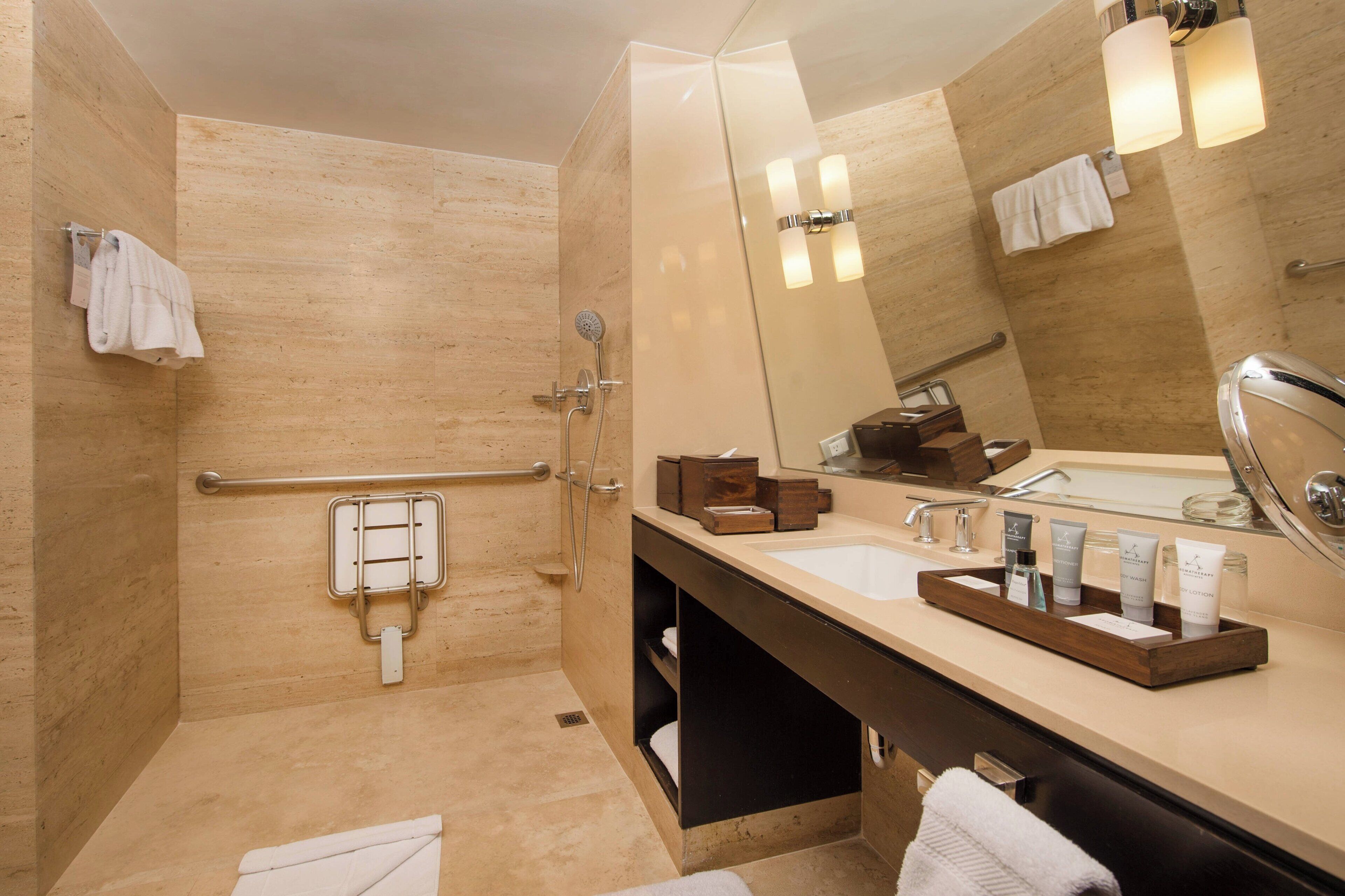 A modern bathroom with a walk-in shower, a vanity with a mirror, and a sink.