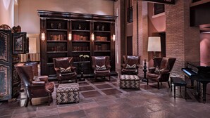 A library with leather chairs and a grand piano. - JW Marriott El Convento Cusco (Cusco)