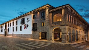A historic building with a stone facade, multiple windows, and an arched entrance. - JW Marriott El Convento Cusco (Cusco)