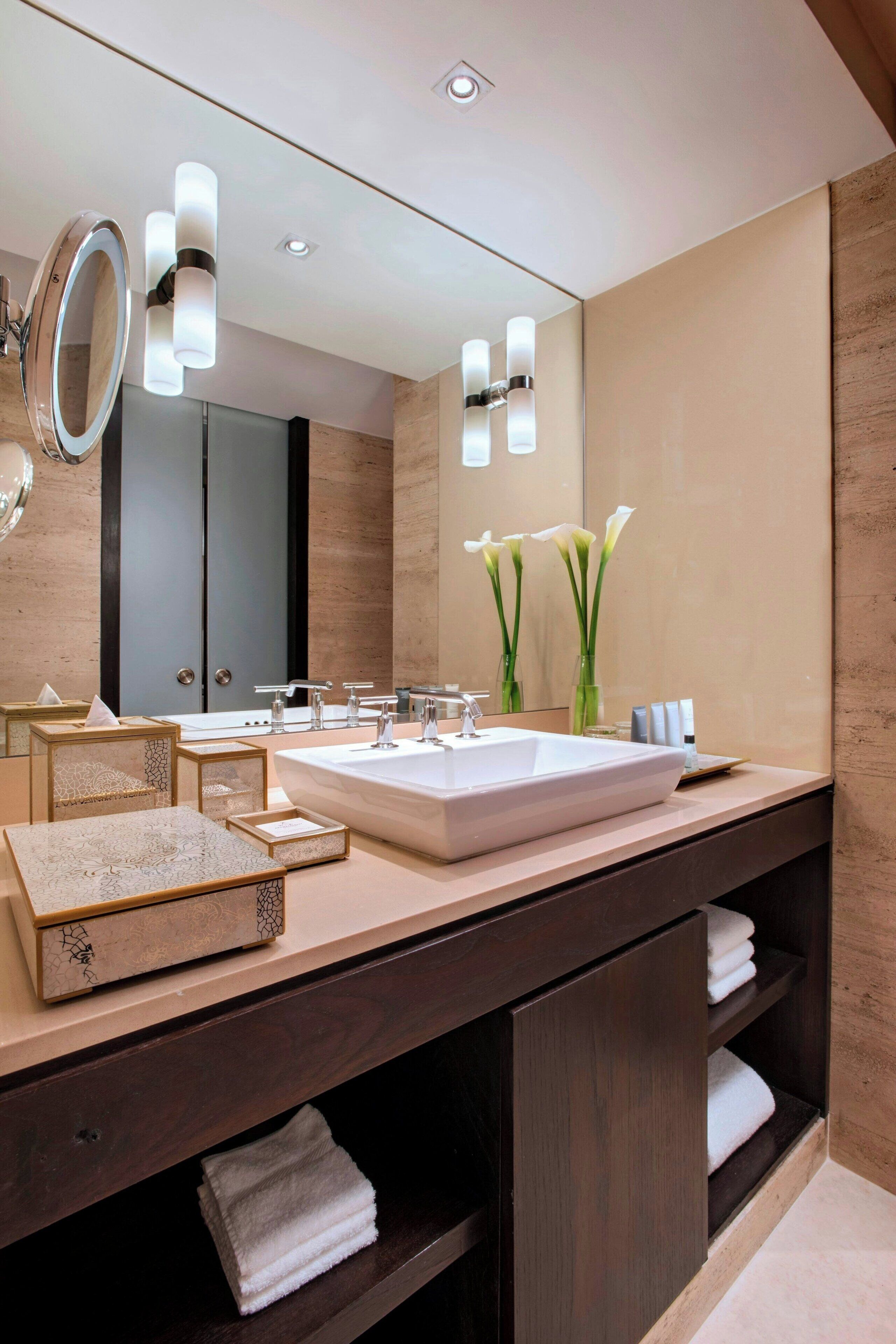 Un baño moderno con un espejo grande, dos lavamanos y un mueble de tocador con espacio de almacenamiento.