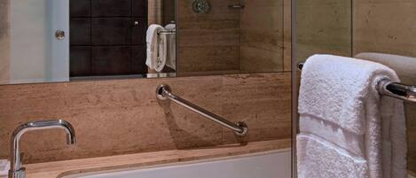 Une salle de bain moderne avec une douche à l’italienne, une baignoire et un grand miroir.