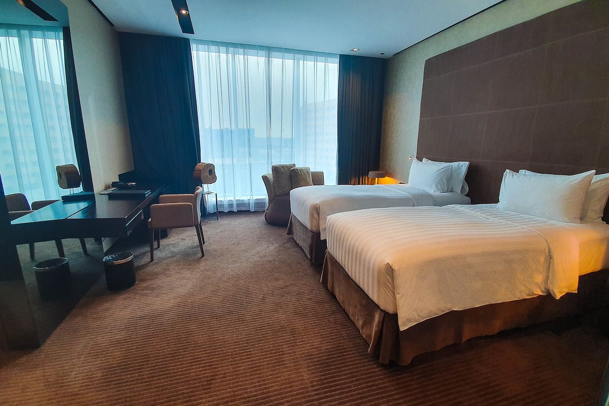 Ein Hotelzimmer mit einem großen Bett, einem Schreibtisch und einem Stuhl.