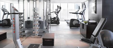 A modern gym with various exercise equipment, including weight machines, treadmills, and stationary bikes.