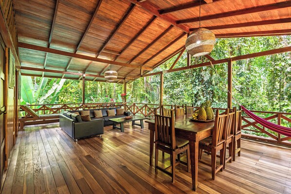 Une terrasse en bois avec une table à manger, des chaises et un canapé.