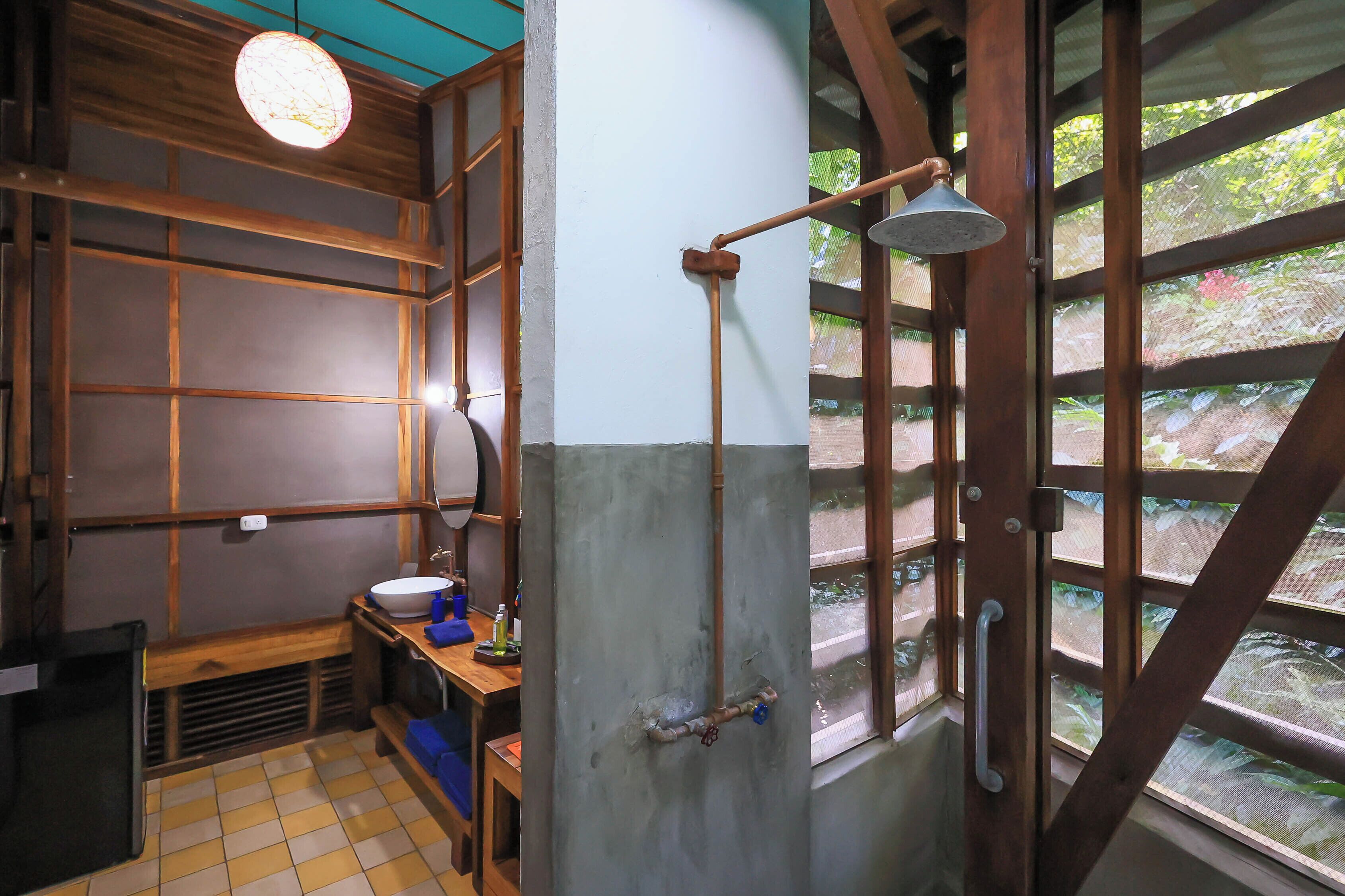 A traditional Japanese-style bathroom with a wooden interior, a sink, and a shower area.